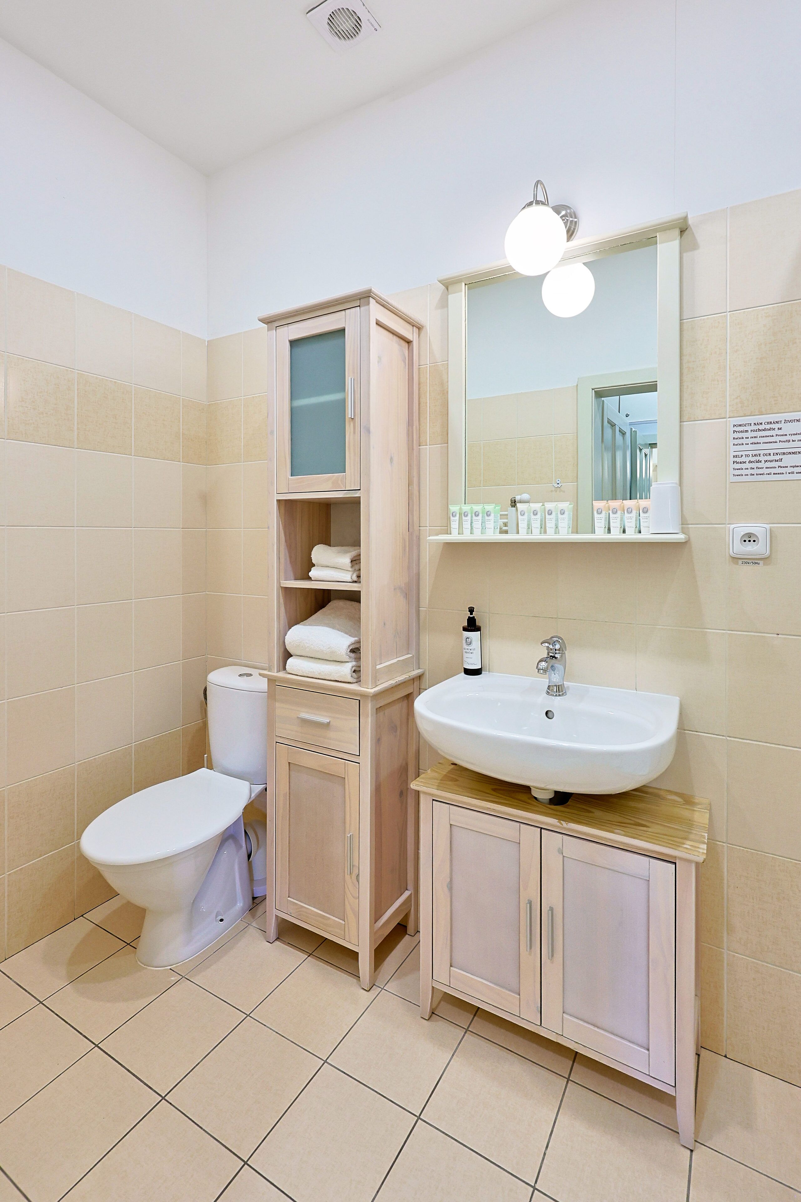 A bathroom with a toilet, sink, and cabinet.