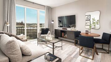A modern living room with a sofa, a glass coffee table, a TV, and a dining area with chairs and a table.