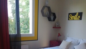 A bedroom with a bed, a window, a wall decoration, and a red nightstand. - Bassin d'Arcachon family home with swimming pool (LE TEICH)