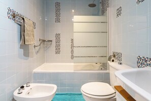 A modern bathroom with a bathtub, a shower, a sink, and a toilet. - Apartment in Fuengirola near train station (Fuengirola)