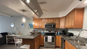 Una cocina moderna con armarios de madera, un lavamanos de acero inoxidable y una encimera de granito.