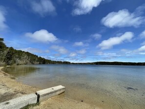 Un lago tranquilo con una playa de arena y una estructura de hormigón.