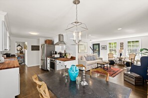 A spacious kitchen with modern appliances, a dining area with a large table, and a living room with comfortable seating. - Wellfleet Beach House (Wellfleet)