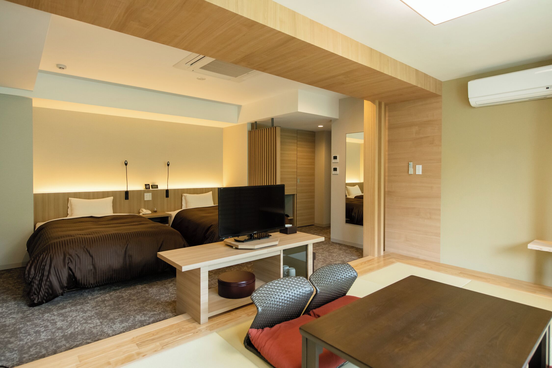 Una habitación de hotel moderna con cama, televisión, escritorio y zona de estar.