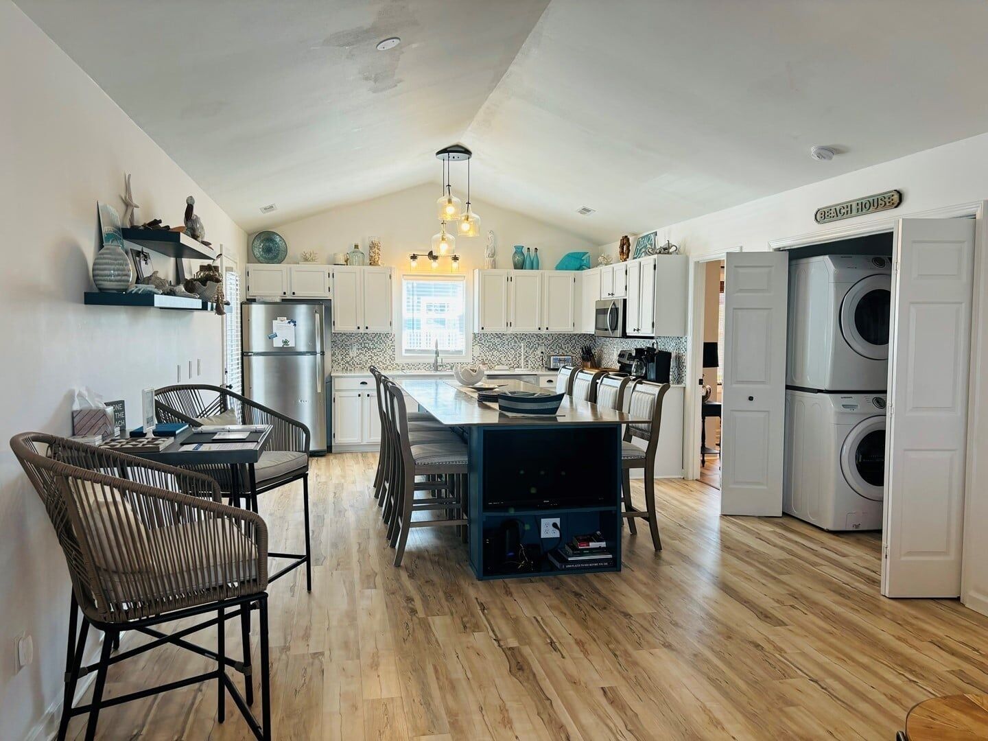 A spacious kitchen with a central island, built-in appliances, and a dining area with chairs.