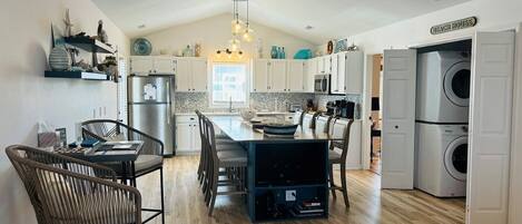 A spacious kitchen with a central island, built-in appliances, and a dining area with chairs.