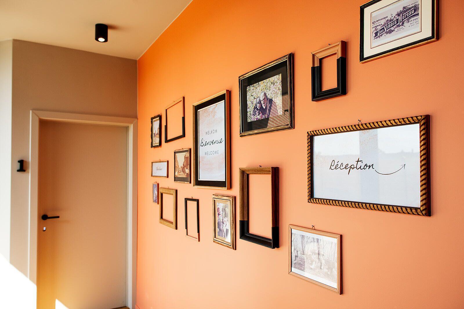 A hallway with a series of framed pictures on the wall, including a welcome sign and a reception sign.
