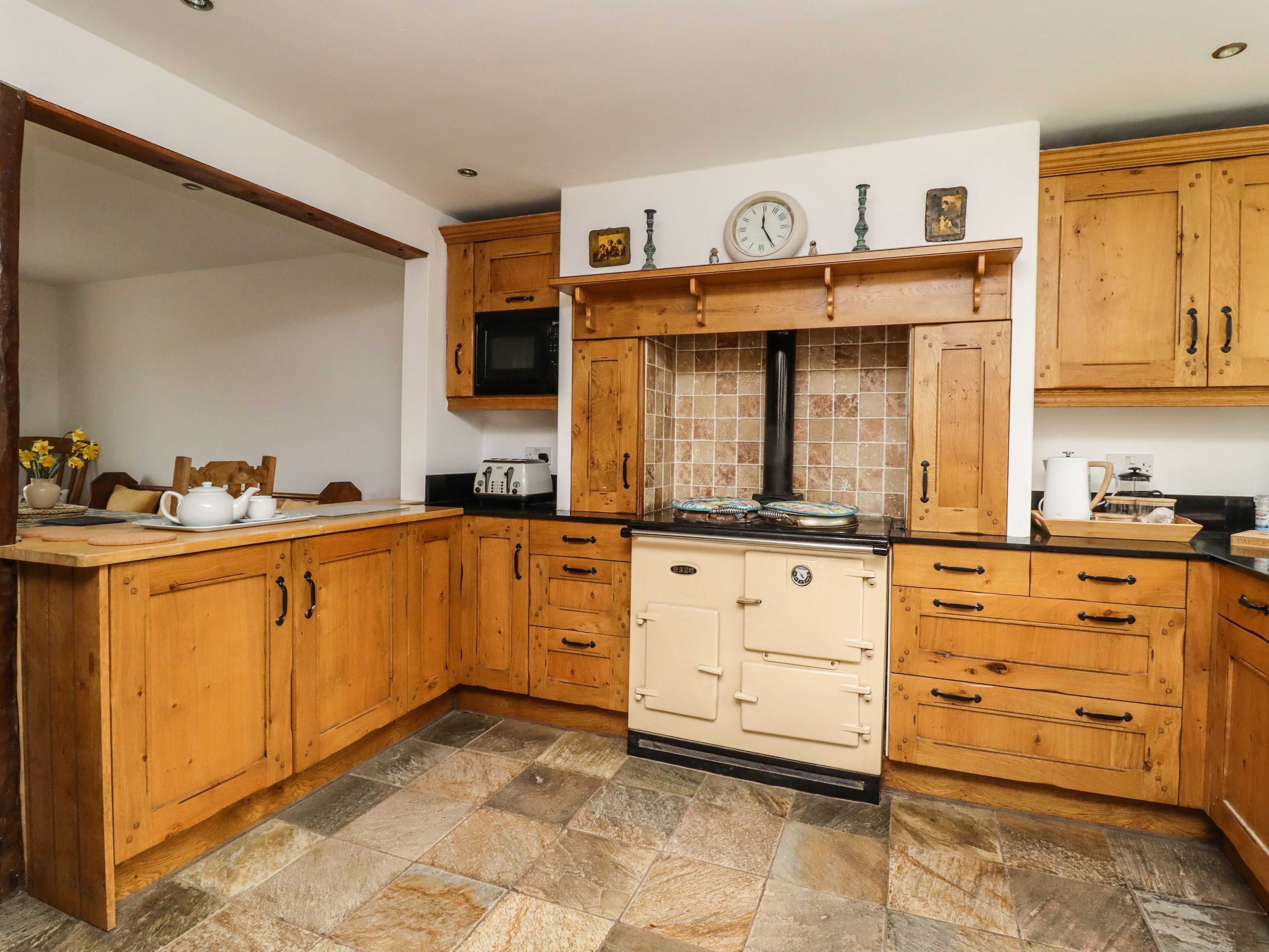 A kitchen with wooden cabinets, a stove, and a microwave.