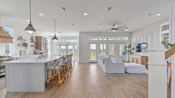 A spacious kitchen with a large island, wooden flooring, and modern pendant lighting. - Marsh front pool home with ocean, river and historical downtown views (St. Augustine)
