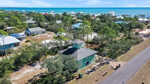 Un quartier résidentiel situé sur la côte, avec des maisons, une route et une vue sur l’océan.
