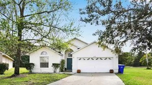 A single-story house with a garage, a front yard, and a driveway. - Entire Villa with Pool and great Privacy near Disney (Kissimmee)