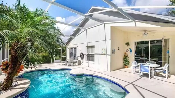 A modern house with a swimming pool, a covered patio, and a large window. - Entire Villa with Pool and great Privacy near Disney (Kissimmee)