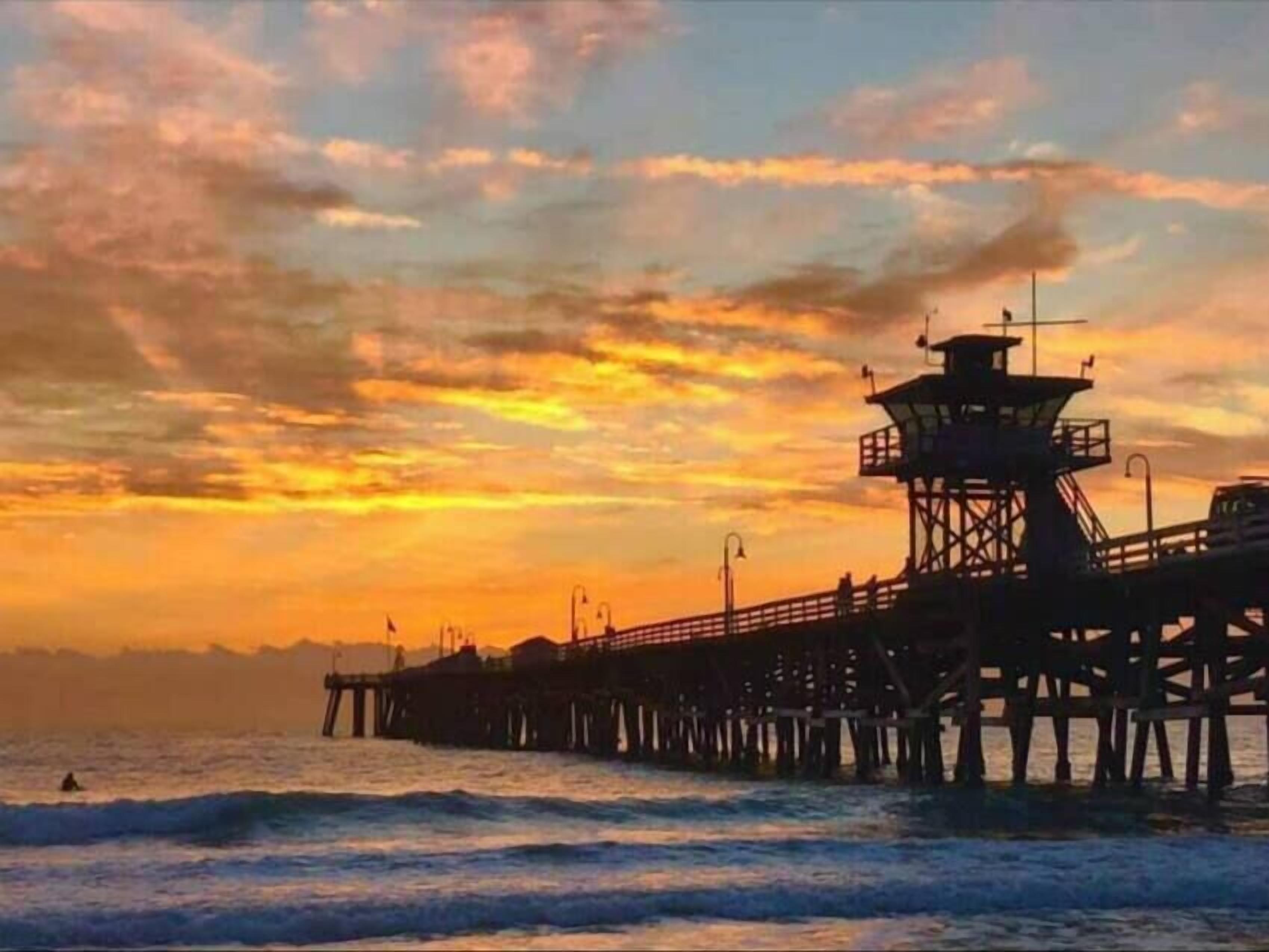 A pier extending into the sea with a lighthouse structure at the end.