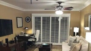 Ein Wohnzimmer mit Sofa, Couchtisch, Fernseher und Deckenventilator.