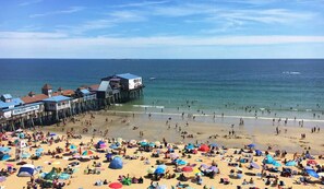 A beach with a pier and beach umbrellas. - Cozy new efficiency close to beach and shopping (Saco)