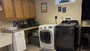 A laundry room with a washing machine, dryer, and a window labeled "LAUNDRY".