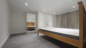 Une chambre à coucher avec un lit, une armoire et une porte.