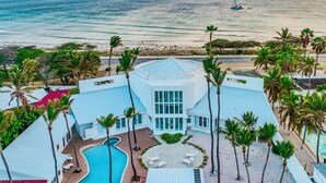 Un resort con piscina, palmeras y vista al océano.