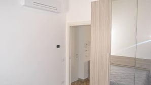Ein Schlafzimmer mit einem Bett, einem Kleiderschrank und einer Tür zu einem Badezimmer.