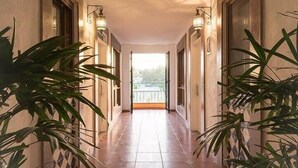 A corridor with tiled flooring, wall-mounted lights, and potted plants. - Unique 2BR Suite at the Best Location in Sayulita (Sayulita)