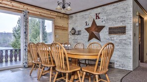 Un'area pranzo con un tavolo e sedie in legno, un'ampia decorazione a stella e un cartello appeso al muro.