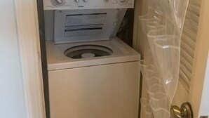 Una lavadora y secadora compactas en un lavadero pequeño.