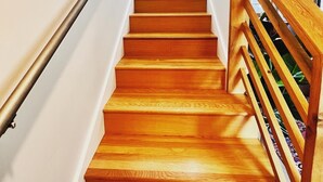 Una escalera de madera con barandilla de metal y balaustres de madera.