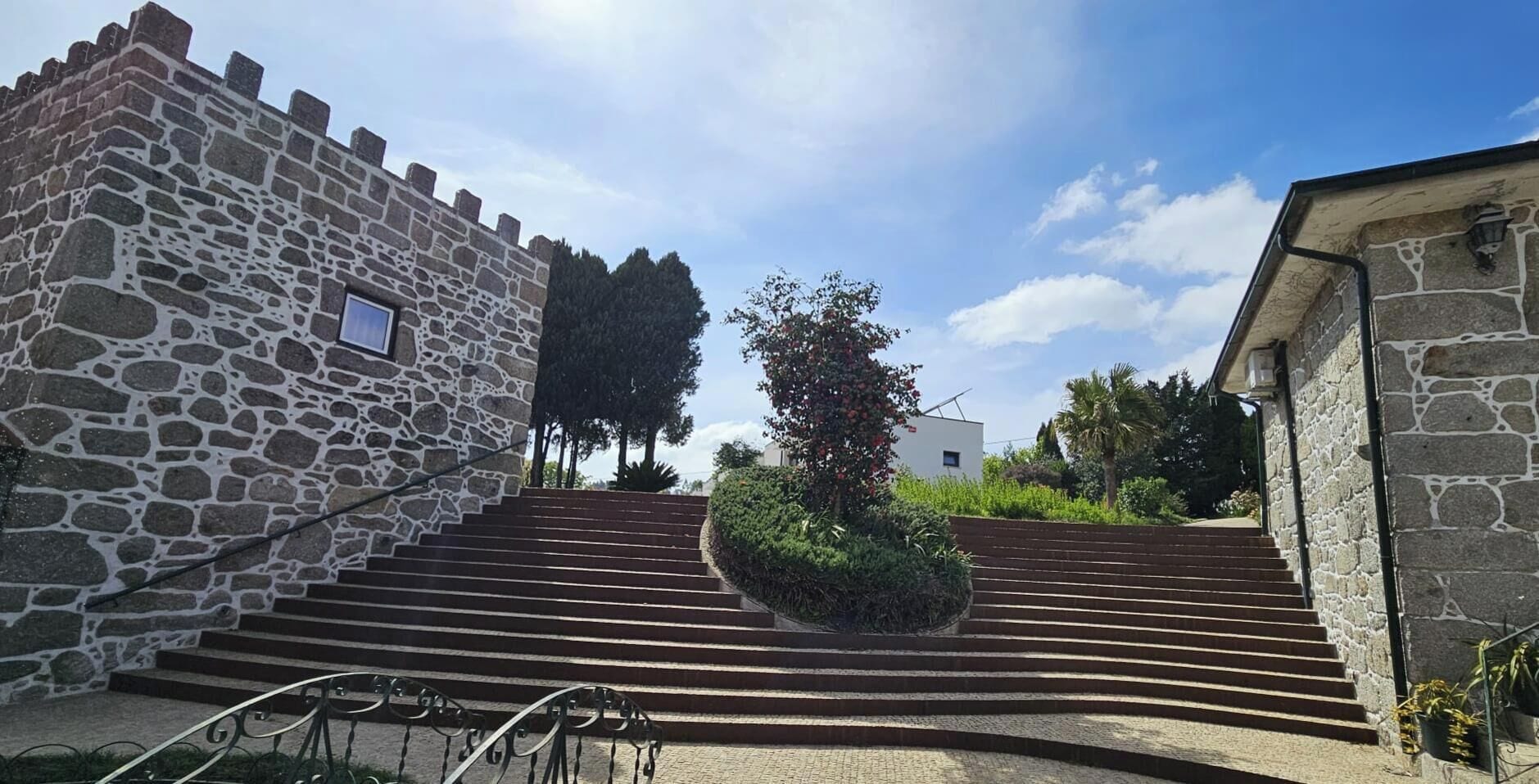 A stone building with a staircase leading to a white structure.