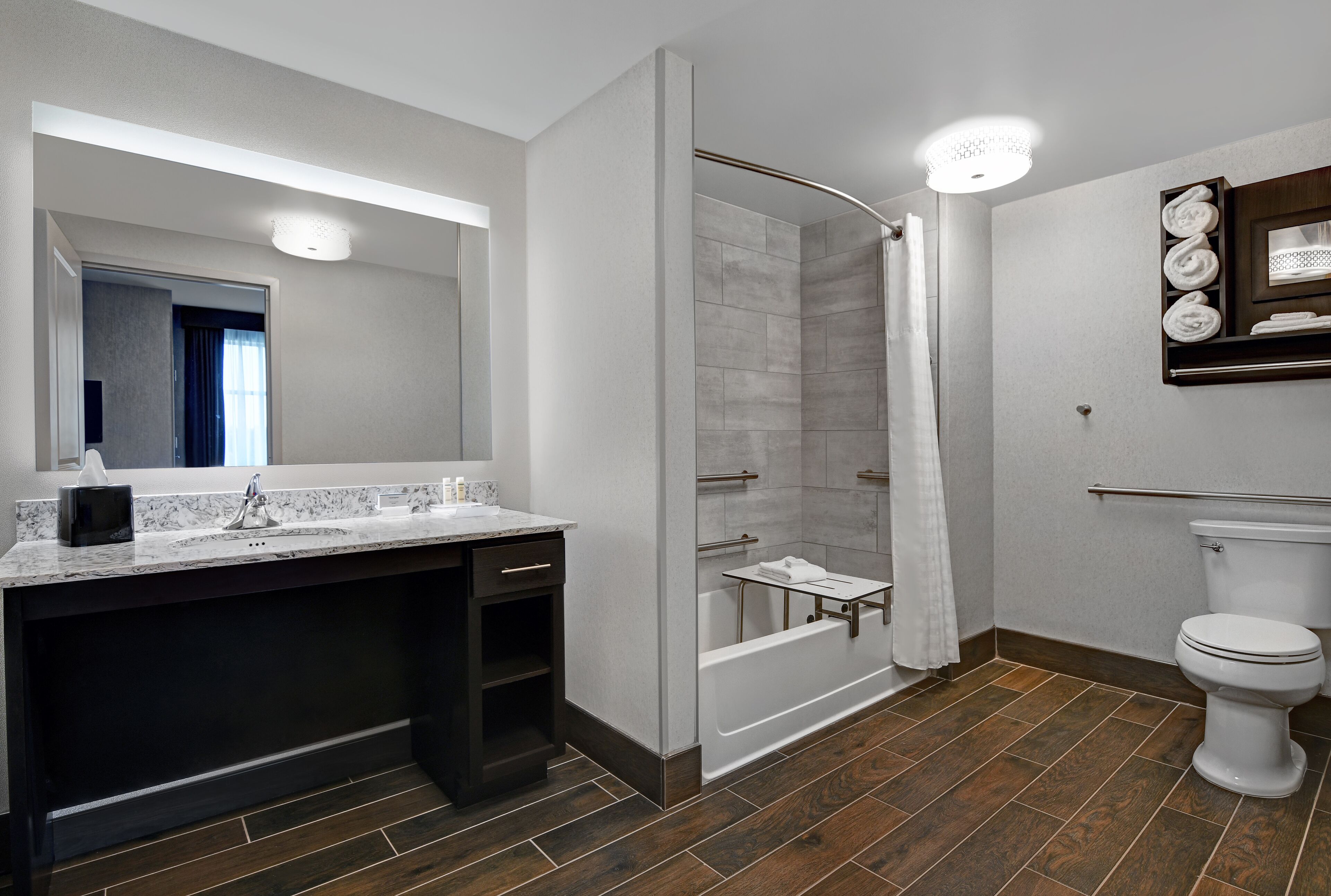 A modern bathroom with a shower, toilet, and sink.