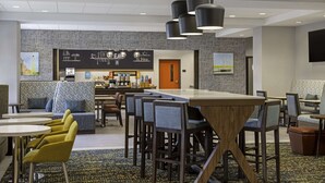 A modern hotel lobby with a bar area, seating arrangements, and a patterned carpet. - Hampton Inn Midland, On (Midland)