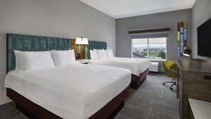 A hotel room with two beds, a desk, a chair, a TV, and a large window with a view. - Hampton Inn Midland, On (Midland)