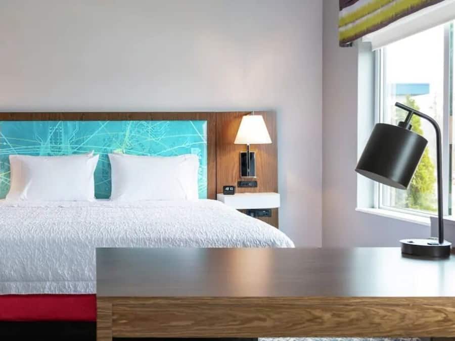 Habitació d'hotel amb un llit, dues làmpades de nit, una taula de nit, una finestra i vistes a l'exterior.