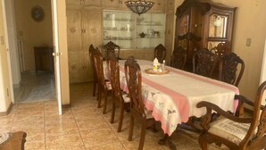 A dining room with a long wooden table, six chairs, and a chandelier. - Beautiful Villa La Concepcion (Cuernavaca)