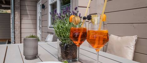 Ein Tisch mit zwei Getränken, einer Blaubeeren-Schale und einer Blumentopf-Pflanze.