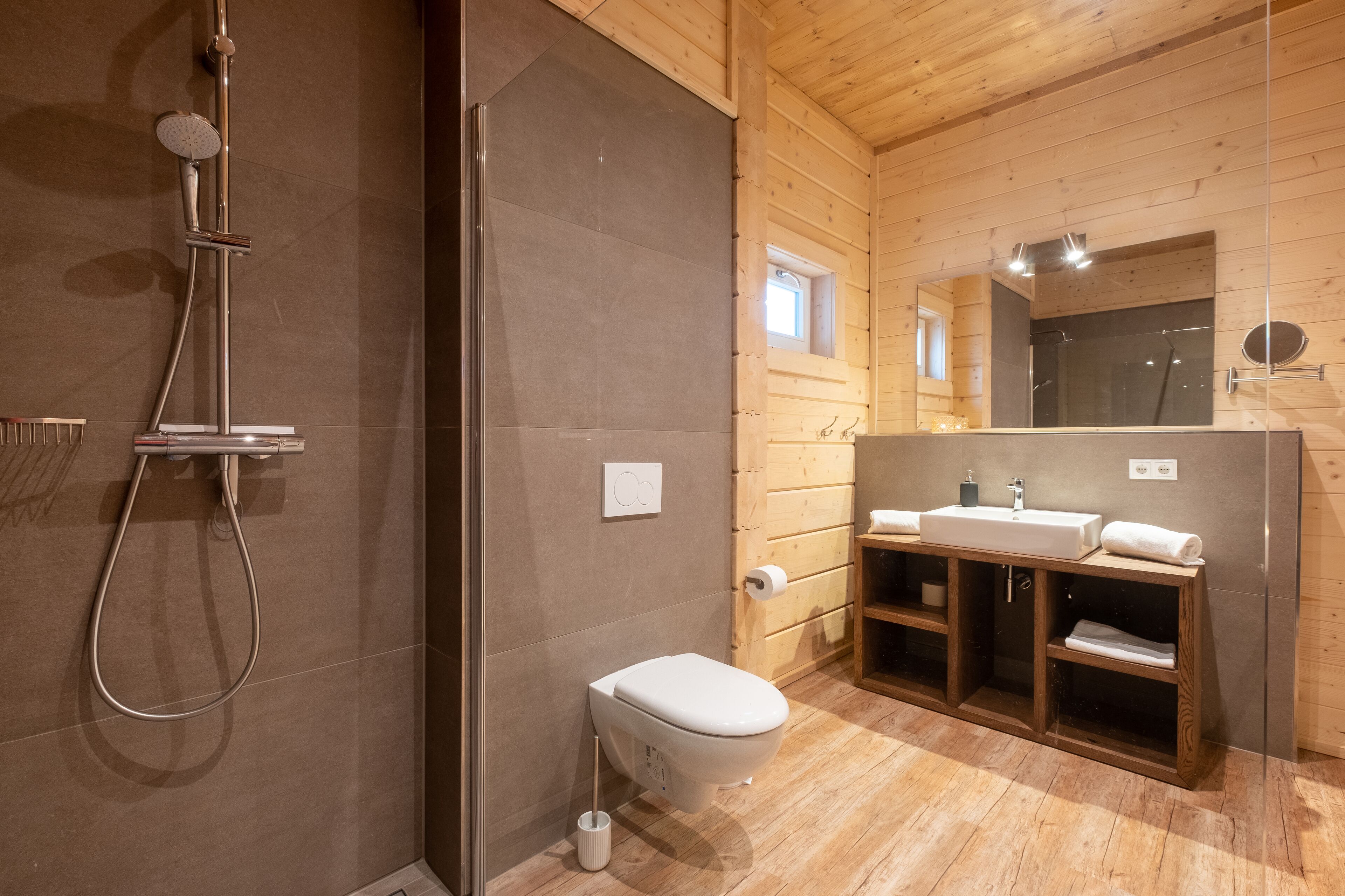 Ein modernes Badezimmer mit Dusche, Toilette und Waschtisch.
