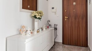 A clean, modern bathroom with a white vanity, a wooden door, and a mirror above the vanity. - Romeo & Julia (Split)