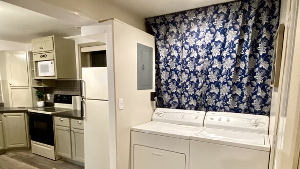 A compact kitchen with a refrigerator, microwave, stove, and a washing machine. - Cozy Studio minutes from Flathead Lake (Bigfork)