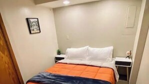 A hotel room with a bed, a nightstand, a framed picture on the wall, and a carpeted floor. - Cozy Studio minutes from Flathead Lake (Bigfork)