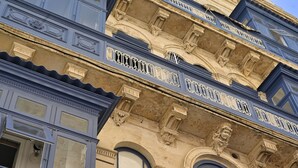 A multi-story building with ornate architectural details, including decorative moldings and a balcony with intricate railings. - Palazzo Ignazio (Valletta)