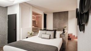 A modern hotel room with a large bed, a bedside table with a vase of flowers, and a built-in wardrobe. - Palazzo Ignazio (Valletta)