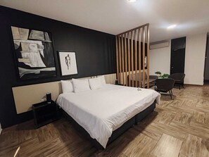 A modern hotel room with a large bed, a desk, and a chair. - Rua Hoteles - Piura (Piura)