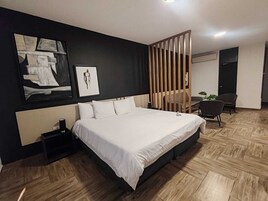 Una habitación de hotel moderna con una cama grande, un escritorio y una silla.