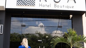 A hotel boutique with a modern facade, a large glass entrance, and a sign indicating a male restroom nearby.