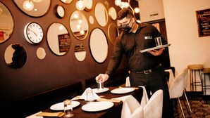 A restaurant with a waiter serving a table.