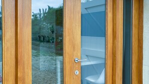 Une porte en bois avec un panneau de verre, une poignée en métal et un trou de serrure.