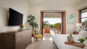 A bedroom with a bed, a TV, a desk, and a view of the outdoors. - Waikoloa Luxe Golf Estate w/ Hilton Pool passes, Gameroom (Puako)