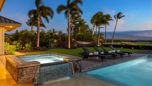 A swimming pool with lounge chairs and a hammock, surrounded by palm trees and a view of the landscape. - Waikoloa Luxe Golf Estate w/ Hilton Pool passes, Gameroom (Puako)
