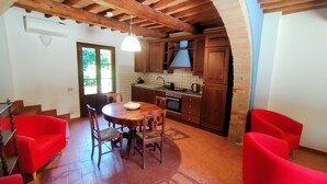 Una cocina con armarios de madera, una estufa y una mesa de comedor con sillas.