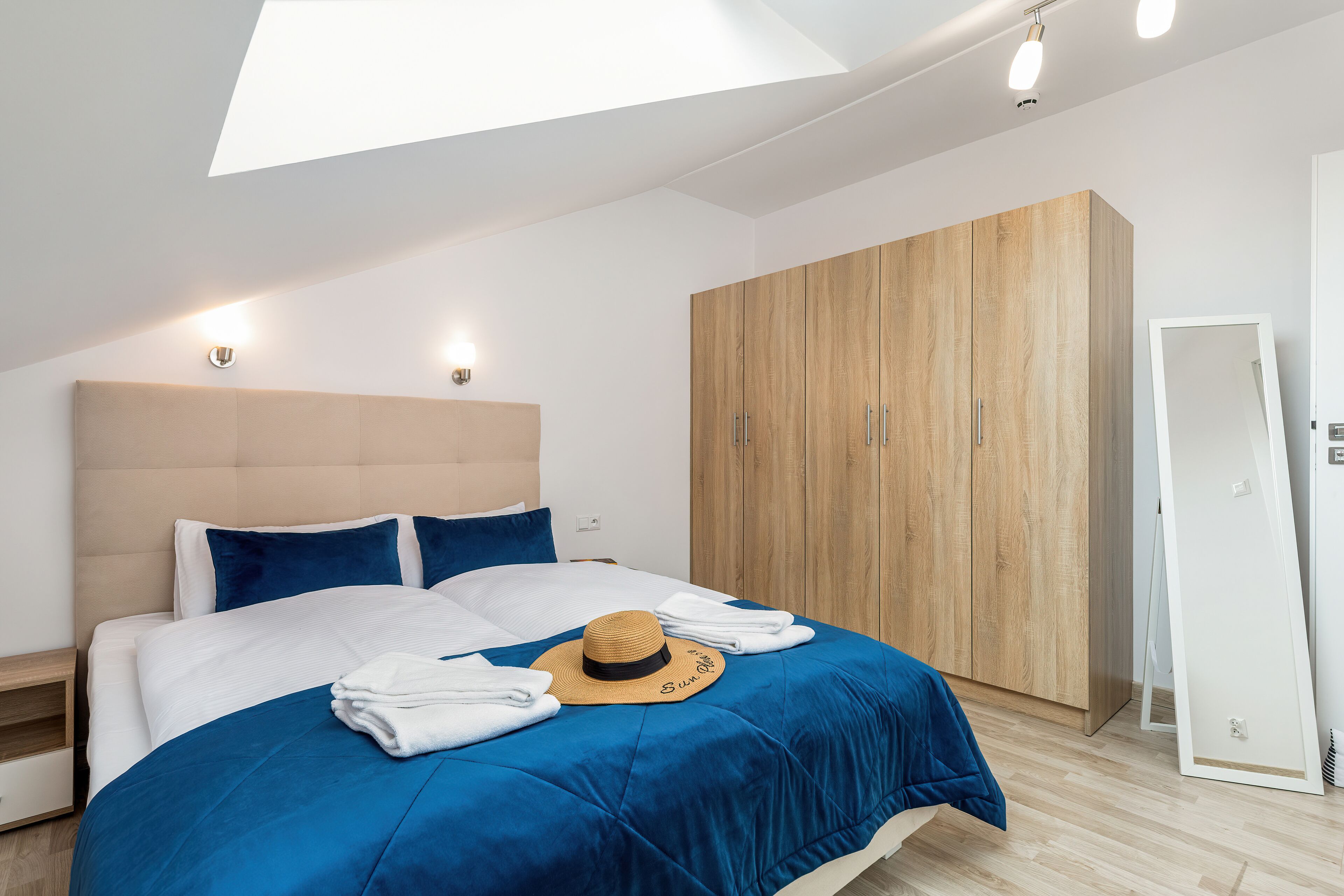 Ein modernes Schlafzimmer mit einem großen Bett, einem Kleiderschrank und einem Oberlicht.