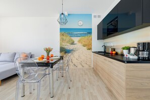 A modern kitchen with a wooden countertop, a built-in oven, and a coffee machine. - Seaside Apartamenty-Grzybowo  (Kolobrzeg)